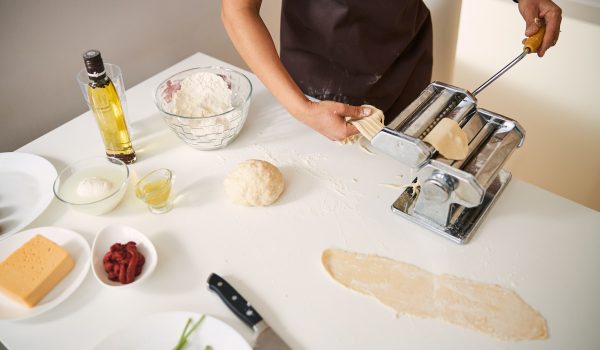 person making homemade pasta with ingredients out on the counter